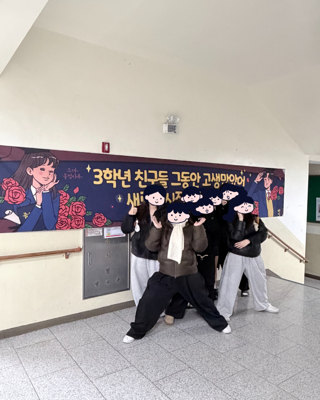 졸업식 후 현수막 앞에서 선생님과 학생들이 함께 찍은 사진 첫 번째